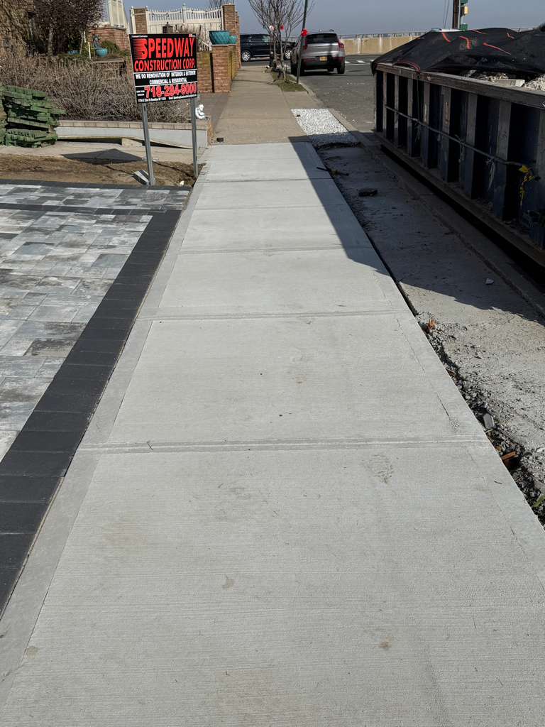 Professional concrete repair contractors fixing damaged sidewalk in Queens New York